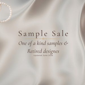 May include: A smooth, light beige satin fabric background with a string of white pearls in the upper left corner. The text reads: Sample Sale, One of a kind samples & Retired designes, Updated June 2026, centered in dark brown lettering.