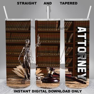 May include: A tumbler with a design featuring a bookshelf filled with law books, a statue of Lady Justice, a gavel, and the word "ATTORNEY" in silver lettering.