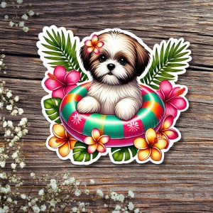 May include: A white and brown Shih Tzu dog wearing a pink and green inflatable ring with tropical flowers.
