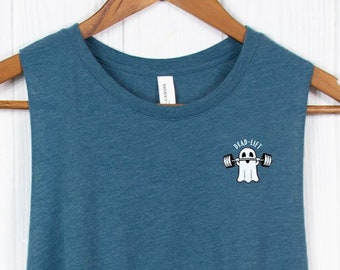 May include: A teal blue sleeveless crop top with a white ghost lifting a barbell with the text "Dead-lift" above it. The shirt has a pink circle with the text "Hustle Vogue" and "Free Customization More Variety" around it.