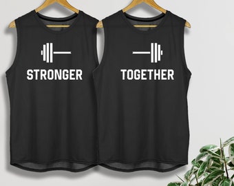 May include: Two black sleeveless shirts with white text and a barbell graphic. The shirt on the left says "Stronger" and the shirt on the right says "Together".