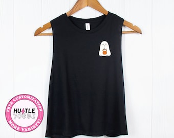 May include: Black sleeveless tank top with a white ghost holding a small orange bucket on the front. The tank top has a pink circle with the text "FREE CUSTOMIZATION" and "HUSTLE VOGUE" in white text and "MORE VARIETY" in white text.
