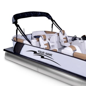 May include: A white pontoon boat with a black canopy and brown and white seats. The boat has a black decal with the text "YOUR NAME" on the side.