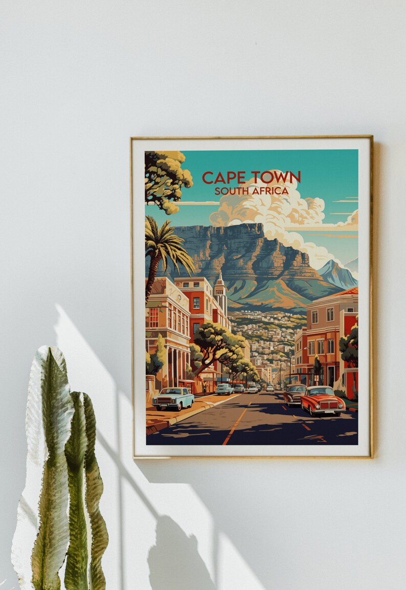 May include: A vintage travel poster featuring a colorful illustration of Cape Town, South Africa. The poster depicts a street scene with buildings, palm trees, and cars. The iconic Table Mountain is visible in the background.