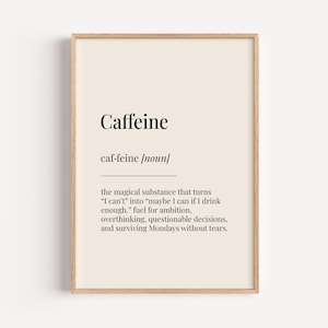 Può includere: Una stampa incorniciata con la definizione di "Caffeine". Il testo nero è su sfondo color crema. La definizione include la frase "la sostanza magica che trasforma 'Non posso' in 'forse posso se bevo abbastanza'". La cornice è marrone chiaro.