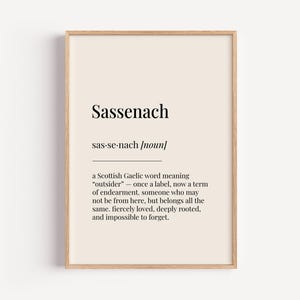 Può includere: Una stampa d'arte da parete stampabile con sfondo beige e testo nero. Il testo definisce la parola "Sassenach" come una parola gaelica scozzese che significa "straniero" e spiega il suo uso come termine di affetto.