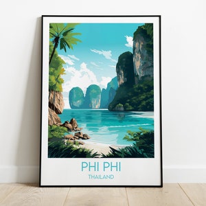 May include: A framed poster featuring a colourful illustration of a tropical island scene. The poster depicts a beach, turquoise water, lush green vegetation, and towering cliffs. The text "PHI PHI THAILAND" is printed at the bottom of the poster.