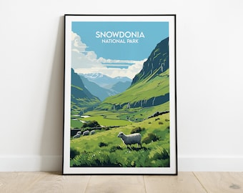 Könnte beinhalten: Ein gerahmter Kunstdruck des Snowdonia Nationalparks. Die Landschaft zeigt ein grünes Tal mit einem Fluss, Bergen und einem blauen Himmel mit Wolken. Der Druck enthält den Text "SNOWDONIA NATIONAL PARK". Ein Schaf ist im Vordergrund.