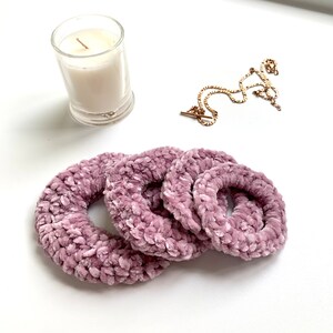 May include: Four dusty rose velvet scrunchies in different sizes.