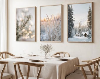 Puede incluir: Tres impresiones enmarcadas de paisajes. La primera presenta una rama de pino con luces borrosas. La segunda muestra hierba helada al atardecer. La tercera representa una cabaña nevada en un bosque con montañas al fondo.