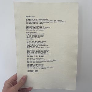 Op de afbeelding: Een rechthoekig vel gebroken wit gestructureerd papier met het gedicht Equivalence, gedrukt in een zwart typemachinelettertype. De tekst verkent thema's als betekenis en identiteit en eindigt met de woorden The word, Love. The name, Ruth.