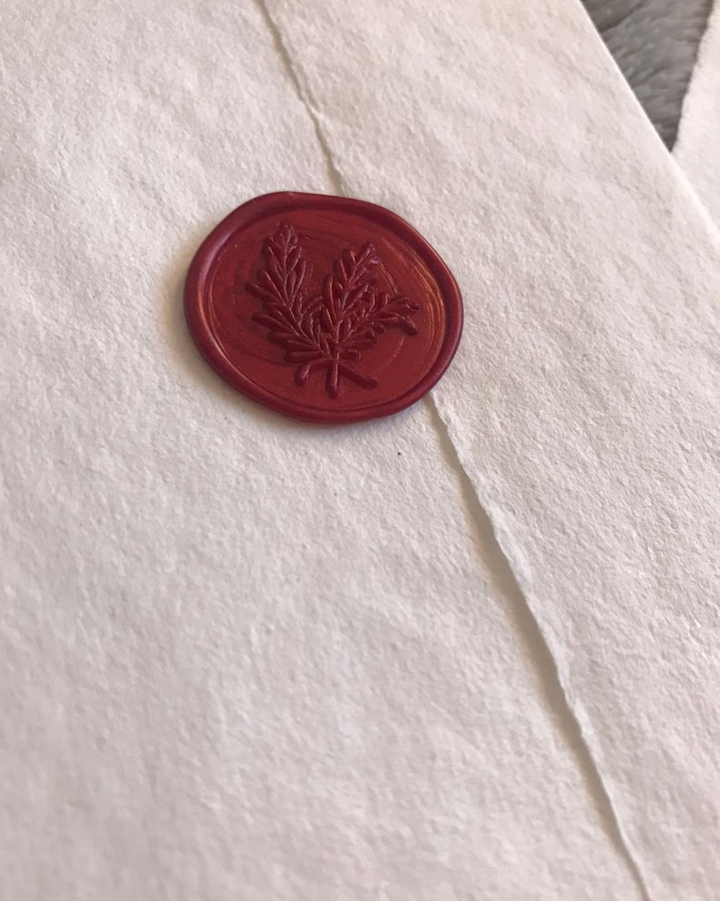 May include: A red wax seal with a leafy design.