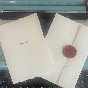Tarjeta de felicitación hecha a mano con papel para máquina de escribir "Te amo"