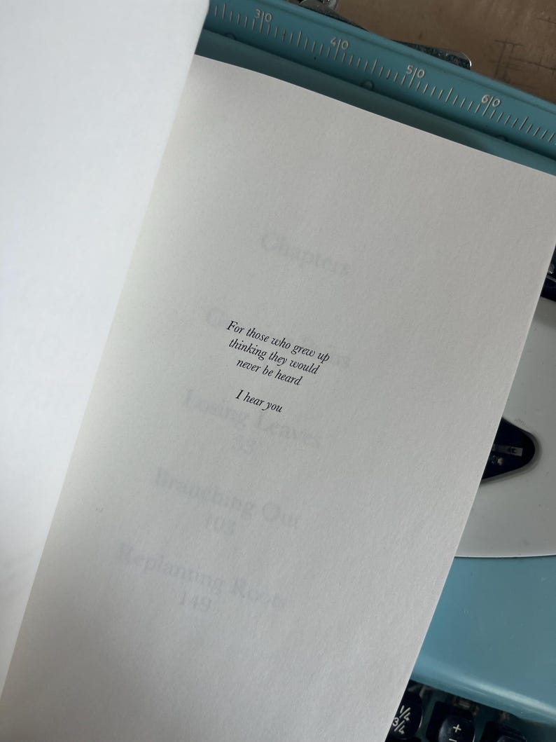 Puede incluir: Un libro abierto con el texto: "Para aquellos que crecieron pensando que nunca ser&iacute;an escuchados. Te escucho." El libro est&aacute; abierto en una p&aacute;gina blanca, con una m&aacute;quina de escribir azul en el fondo.
