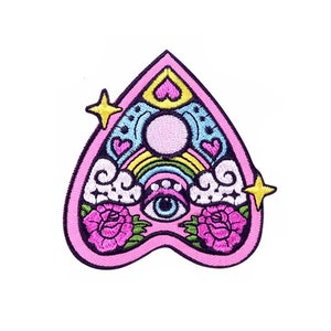 Peut inclure: Patch brodé en forme de cœur rose avec un arc-en-ciel, des nuages, un seul œil et deux roses roses. Le patch a une étoile dorée de chaque côté.