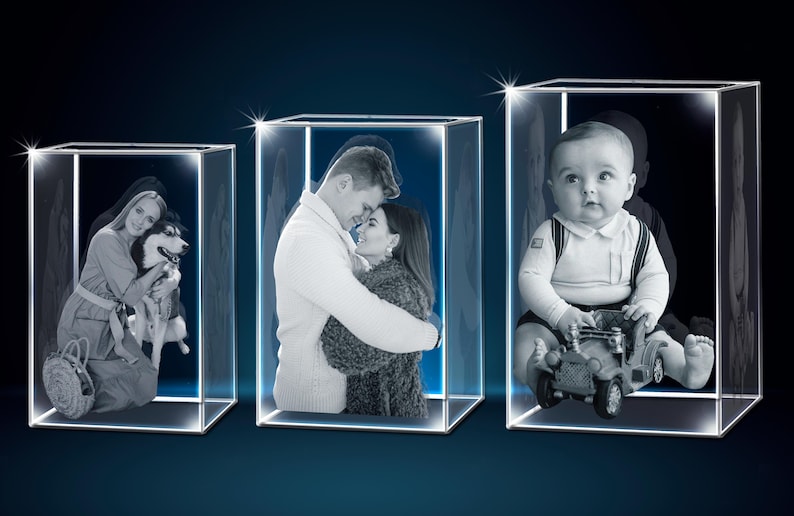 Puede incluir: Tres cajas de exhibici&oacute;n de vidrio iluminadas que muestran grabados fotogr&aacute;ficos personalizados. Las im&aacute;genes presentan a una mujer con un perro, una pareja abraz&aacute;ndose y un beb&eacute; con un coche de juguete. Dise&ntilde;o moderno y minimalista.