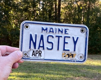 Vintage Maine Motorcycle License Plate: NASTEY Vanity Tag, White on Blue