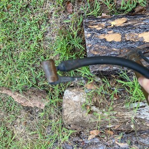 Puede incluir: Primer plano de una bomba de bicicleta negra y plateada con una boquilla de metal. La bomba est&aacute; sobre una superficie de madera.