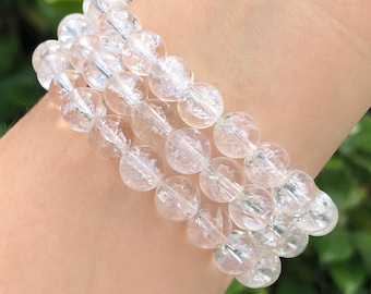 May include: A clear crystal bracelet with multiple strands of round beads. The beads have a sparkly, icy appearance.