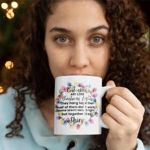 Puede incluir: Taza de cer&aacute;mica blanca con un dise&ntilde;o de luces de Navidad coloridas y el texto "Coworkers are like Christmas Lights. They hang together, half of them don't work, some aren't very bright, but together they Shine."