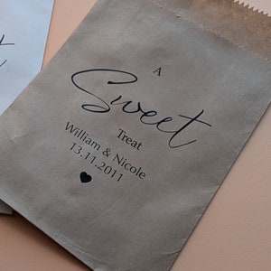 May include: A brown paper bag with the text "A Sweet Treat William & Nicole 13.11.2011" and a small heart.