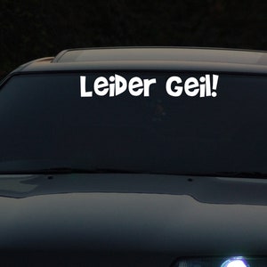 以下が含まれることがあります： 「Leider Geil!」と書かれた白いステッカーが貼られた黒い車