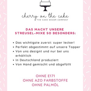 May include: A pink and white graphic with the text "cherry on the cake" and "THE CAKE DECOR COMPANY". The text "DAS MACHT UNSERE STREUSEL-MIXE SO BESONDERS:" is also included. The graphic lists the following features: "super lecker!", "Perfekt abgestimmt auf unsere Topper", "Von uns designt und nur bei uns erh&auml;ltlich", "In Deutschland produziert", "Von Hand gemischt und abgef&uuml;llt", "OHNE E171", "OHNE AZO FARBSTOFFE", "OHNE PALM&Ouml;L".