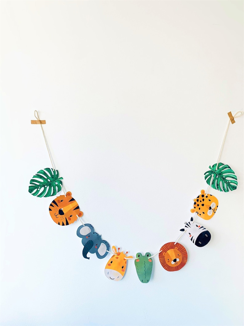 May include: A colorful garland with animal faces and green leaves. The animals include a tiger, elephant, giraffe, crocodile, lion, zebra, and leopard.
