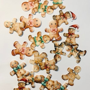 Könnte beinhalten: Eine Ansammlung von Lebkuchenmann-Ausschnitten mit verschiedenen farbigen Schleifen, Knöpfen und Weihnachtsmützen. Die Lebkuchenmänner sind mit Zuckergussdetails und lächelnden Gesichtern verziert. Ideal für Weihnachtsdekorationen.