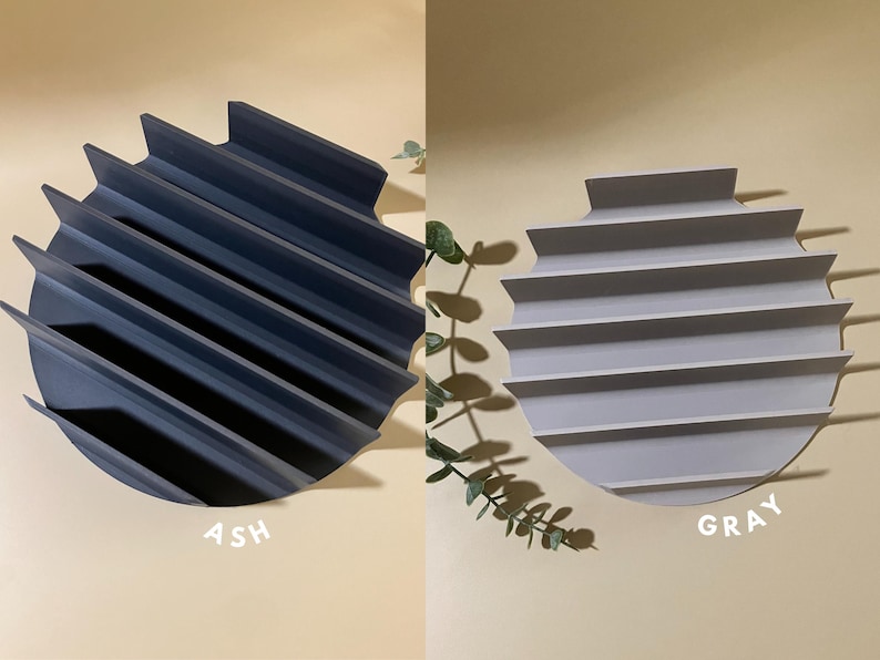 Puede incluir: Dos bandejas redondas decorativas con un dise&ntilde;o acanalado. La bandeja de la izquierda es de color ceniza y la bandeja de la derecha es gris.