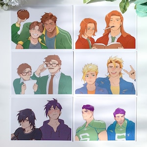 May include: Set of six art prints featuring colorful illustrations of male characters. Each print showcases two characters in various poses and outfits, with a focus on character design and expressions. The prints are on a white background.