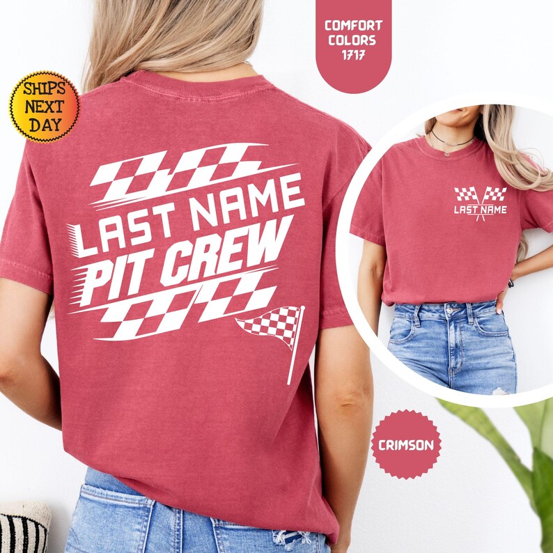 May include: Red t-shirt with white text that says "Last Name Pit Crew" and a checkered flag design. The shirt is shown on a model wearing blue jeans.