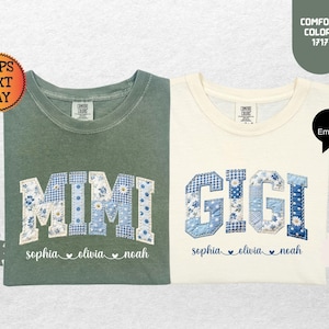 May include: Two Comfort Colors t-shirts, one moss green and one ivory. Each shirt features a floral patchwork design spelling "MIMI" and "GIGI" in blue and white. Below the names are the names "sophia olivia noah".