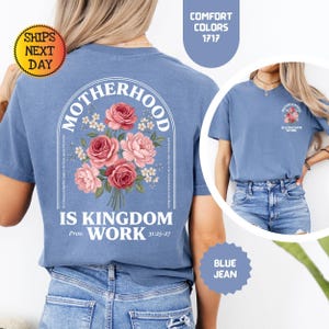 Pu&ograve; includere: T-shirt blu jeans con la scritta "MOTHERHOOD IS KINGDOM WORK" e un design a bouquet floreale. La maglietta ha girocollo e maniche corte. Il testo "SHIPS NEXT DAY" &egrave; su un cerchio giallo.