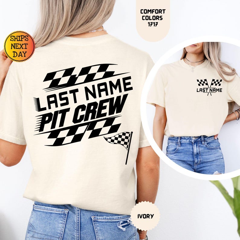 May include: A white t-shirt with a black checkered flag design and the text "Last Name Pit Crew". The shirt is shown on a model wearing blue jeans. The shirt is available in ivory.