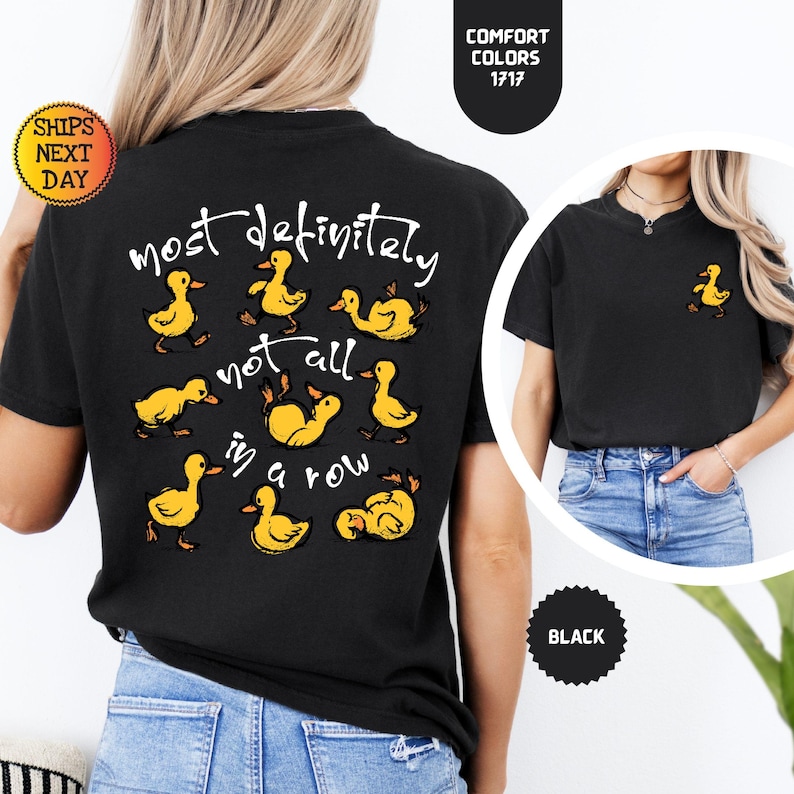May include: Black t-shirt with a yellow duck graphic and the text "most definitely not all in a row." A small yellow duck graphic is on the front. The shirt is made of a soft, comfortable material.