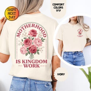 Pu&ograve; includere: T-shirt color avorio con un motivo floreale di rose rosa e la scritta "MOTHERHOOD IS KINGDOM WORK" ad arco. La maglietta ha girocollo e maniche corte. Il testo "Prov. 31:25-27" &egrave; anch'esso stampato.