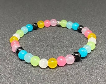 May include: A colourful beaded bracelet with alternating light blue, light green, white, yellow, and pink beads. The bracelet also has black beads interspersed throughout.