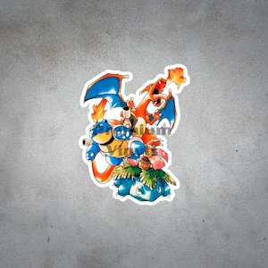 May include: A sticker featuring three colorful Pokémon characters: Blastoise, Charizard, and Venusaur. Blastoise is blue with a yellow belly, Charizard is orange with blue wings, and Venusaur is green with a large flower.