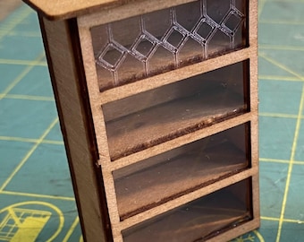 May include: A wooden miniature display cabinet with four shelves and a glass front. The glass has a diamond pattern.