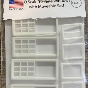 Könnte beinhalten: Eine Packung weißer O-Scale-10-Pane-Fenster mit beweglichen Rahmen für Miniaturprojekte. Das Paket enthält mehrere Fensterrahmen und -flügel. Die Verpackung enthält den Text "BUNGALOW MINIATURES" und "MADE IN USA".