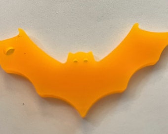 May include: A bright orange plastic bat cutout. The bat is a Halloween decoration.