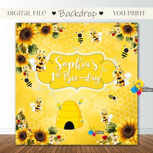 Puede incluir: Un telón de fondo amarillo y negro con temática de abejas con un patrón de panal, girasoles y abejas. El texto "Sophia's 1st Bee-day" está escrito en un marco blanco.