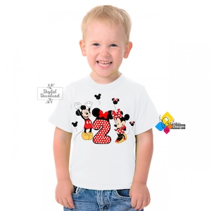 May include: White t-shirt with a red and black Mickey Mouse and Minnie Mouse design. The design features Mickey Mouse and Minnie Mouse holding red balloons with a red number 2 with white polka dots in the center.