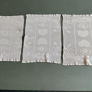 A set of three vintage blush pink crocheted lace placemats with hearts