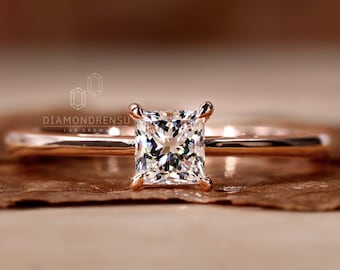 Op de afbeelding: Een verlovingsring van roségoud met een vierkante diamant. De ring is gezet op een eenvoudige band.