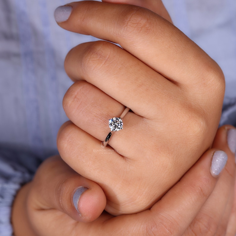 Exquisite selection of rings for women, prominently featuring a lab grown diamond with radiant sparkle on a satin backdrop.