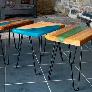 May include: Three wooden side tables with black hairpin legs. The tabletops feature a river of blue, teal, and green epoxy resin.