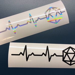 Könnte beinhalten: Zwei Vinyl-Aufkleber mit einem schwarzen und weißen Herzschlag und einem schwarzen und weißen 20-seitigen Würfel sowie einem regenbogenfarbenen, schillernden Herzschlag und einem regenbogenfarbenen, schillernden 20-seitigen Würfel.