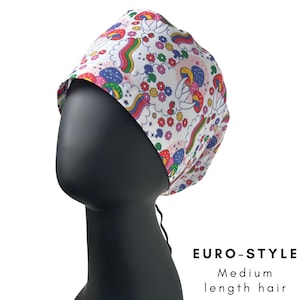 May include: A white Euro-style scrub cap with a colorful pattern of mushrooms, rainbows, and flowers. The cap is designed for medium-length hair. The text "EURO-STYLE" and "Medium length hair" are printed on the image.